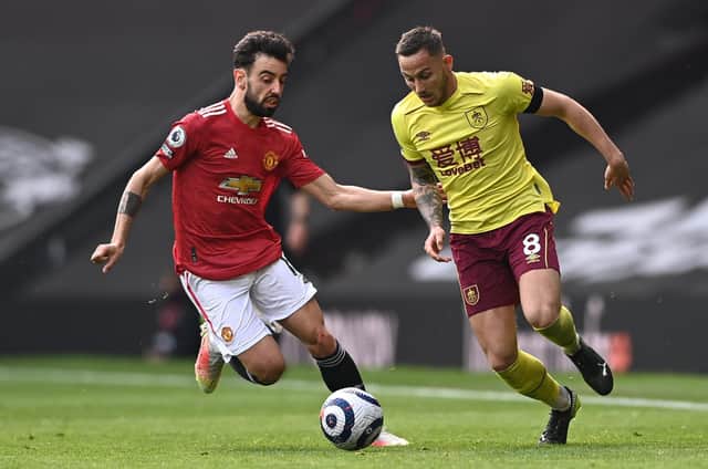 Josh Brownhill of Burnley is challenged by Bruno Fernandes during the Premier League match between Manchester United and Burnley at Old Trafford on April 18, 2021 in Manchester, England.
