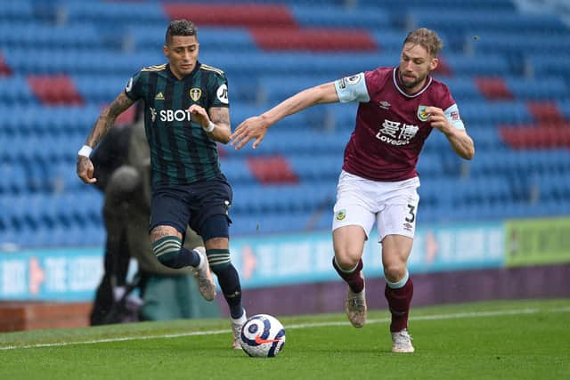 Charlie Taylor of Burnley battles for possession with Raphinha of Leeds United during the Premier League match between Burnley and Leeds United at Turf Moor on May 15, 2021 in Burnley, England.