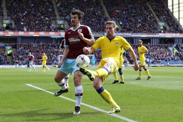 Charlie Taylor of Leeds clears the ball from Joey Barton of Burnley during the Sky Bet Championship match between Burnley and Leeds United at Turf Moor on April 9, 2016 in Burnley, United Kingdom.