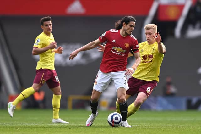 Edinson Cavani of Manchester United holds off Ben Mee of Burnley during the Premier League match between Manchester United and Burnley at Old Trafford on April 18, 2021 in Manchester, England.