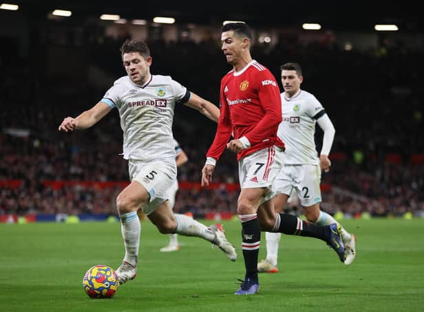 Cristiano Ronaldo of Manchester United is challenged by James Tarkowski of Burnley during the Premier League match between Manchester United and Burnley at Old Trafford on December 30, 2021 in Manchester, England.
