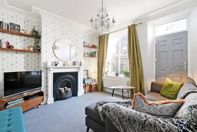 The front facing, bright and airy living room has lovely decor and a feature, decorative cast iron fireplace.