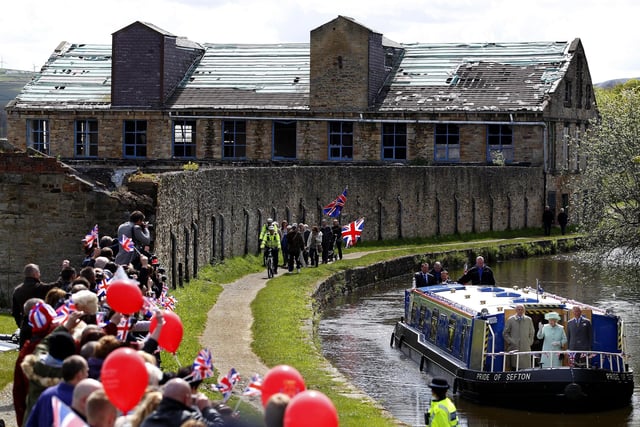 Queen Elizabeth II, The Duke of Edinburgh and The Prince of Wales make their way along the Leeds and Liverpool canal on a barge called the Pride Of Sefton, during a trip to Burnley, Lancashire. PRESS ASSOCIATION Photo. Picture date: Wednesday May 16, 2012. The Queen and Duke are taking part in a two day tour of the North West as part of this years Jubilee celebrations. Photo credit should read: Dave Thompson/PA Wire
