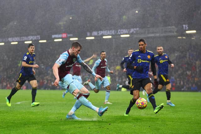 BURNLEY, ENGLAND - FEBRUARY 08: Wout Weghorst of Burnley shoots under pressure from Raphael Varane of Manchester United during the Premier League match between Burnley and Manchester United at Turf Moor on February 08, 2022 in Burnley, England. (Photo by Clive Brunskill/Getty Images)