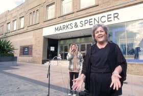Charter Walk shopping centre manager Debbie Hernon speaks about the launch of The Busk Factor competition  as singer Sophie Stott serenades shoppers in the background.