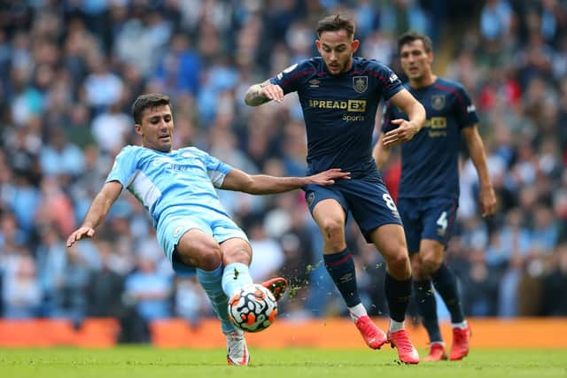 MANCHESTER, ENGLAND - OCTOBER 16: Rodrigo of Manchester City and Josh Brownhill of Burnley battle for the ball during the Premier League match between Manchester City and Burnley at Etihad Stadium on October 16, 2021 in Manchester, England. (Photo by Alex Livesey/Getty Images)