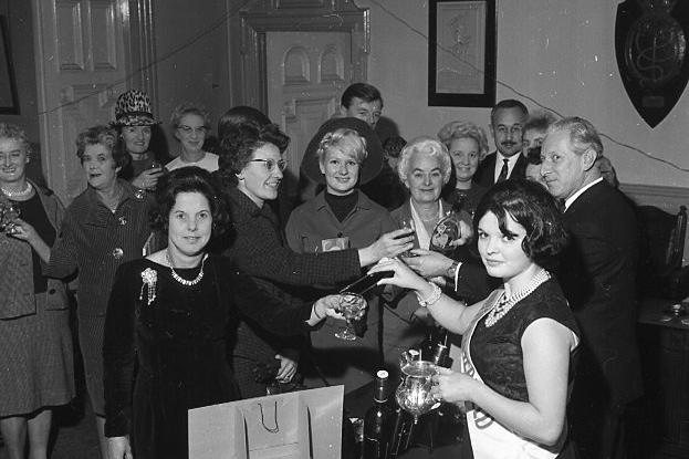 Miss Brierfield (Miss V. Catterall) dispensing ice during the cheese and wine party with other guests in the background.