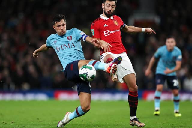 MANCHESTER, ENGLAND - DECEMBER 21: Jack Cork of Burnley contends for the ball with Bruno Fernandes of Manchester United during the Carabao Cup Fourth Round match between Manchester United and Burnley at Old Trafford on December 21, 2022 in Manchester, England. (Photo by Lewis Storey/Getty Images)