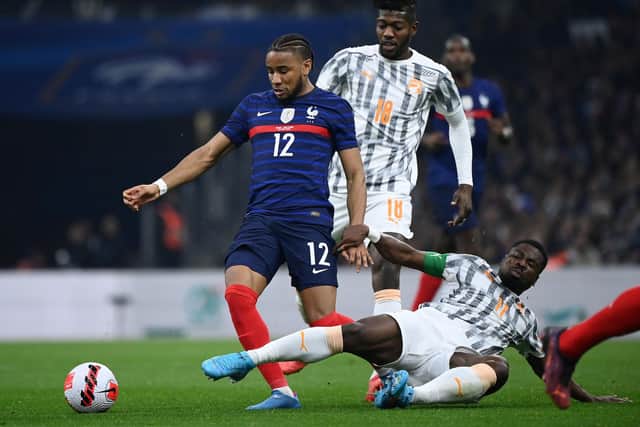 France's forward Christopher Nkunku (L) fights for the ball with Ivory Coast's forward Maxwel Cornet during the friendly football match between France and Ivory Coast at the Velodrome Stadium in Marseille, southern France, on March 25, 2022. (Photo by FRANCK FIFE / AFP) (Photo by FRANCK FIFE/AFP via Getty Images)