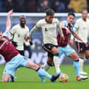 BURNLEY, ENGLAND - FEBRUARY 13: Roberto Firmino of Liverpool is challenged by Ben Mee and Ashley Westwood of Burnley during the Premier League match between Burnley and Liverpool at Turf Moor on February 13, 2022 in Burnley, England. (Photo by Alex Livesey/Getty Images)