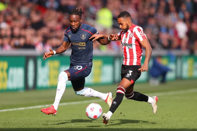 BRENTFORD, ENGLAND - MARCH 12: Maxwel Cornet of Burnley battles for possession with Rico Henry of Brentford during the Premier League match between Brentford and Burnley at Brentford Community Stadium on March 12, 2022 in Brentford, England.