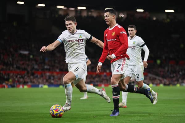 MANCHESTER, ENGLAND - DECEMBER 30: Cristiano Ronaldo of Manchester United is challenged by James Tarkowski of Burnley during the Premier League match between Manchester United and Burnley at Old Trafford on December 30, 2021 in Manchester, England. (Photo by Clive Brunskill/Getty Images)