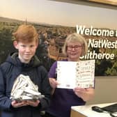 George Hargreaves (13) presents a cake to staff at the NatWest to thank them for their loyal service on one of the final days before the bank closed