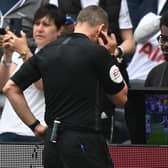 English referee Kevin Friend consults the pitch-side monitor to check a handball after a VAR (Video Assistant Referee) review during the English Premier League football match between Tottenham Hotspur and Burnley at Tottenham Hotspur Stadium in London, on May 15, 2022.