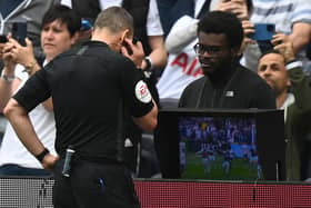 English referee Kevin Friend consults the pitch-side monitor to check a handball after a VAR (Video Assistant Referee) review during the English Premier League football match between Tottenham Hotspur and Burnley at Tottenham Hotspur Stadium in London, on May 15, 2022.