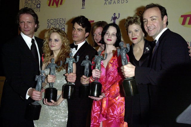 The cast of the film American Beauty. (From L-R:) Chris Cooper, Mena Suvari, Peter Gallagher, Allison Janney, Thora Birch, Annette Bening and Kevin Spacey hold the awards they won for best ensemble cast for a motion picture during the 6th Annual Screen Actor's Guild Awards 12 March 2000 in Los Angeles.Credit: LUCY NICHOLSON/AFP via Getty Images