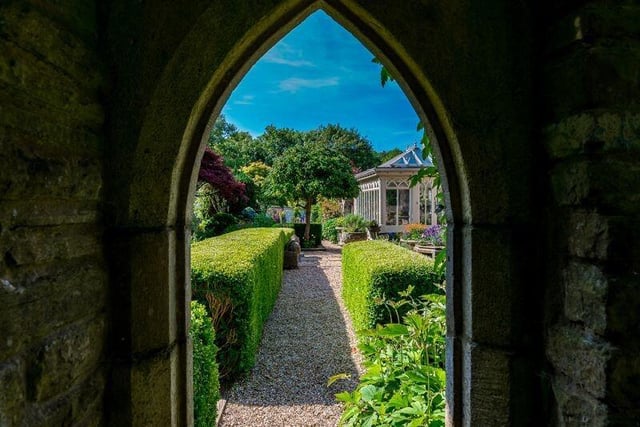 An arched view of the orangery and garden