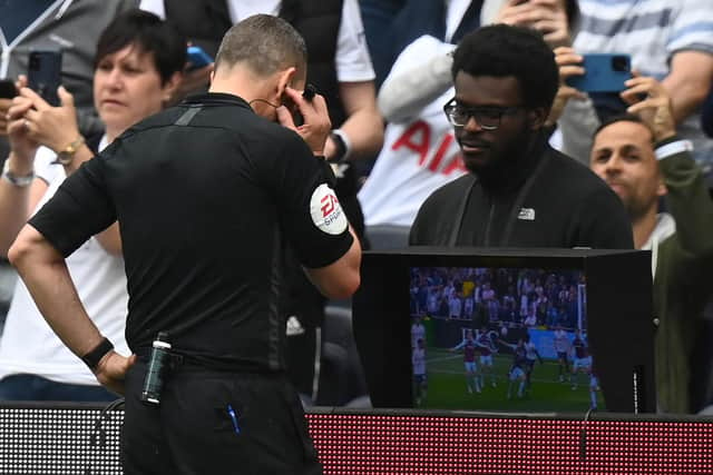 English referee Kevin Friend consults the pitch-side monitor to check a handball after a VAR (Video Assistant Referee) review during the English Premier League football match between Tottenham Hotspur and Burnley at Tottenham Hotspur Stadium in London, on May 15, 2022. - - RESTRICTED TO EDITORIAL USE. No use with unauthorized audio, video, data, fixture lists, club/league logos or 'live' services. Online in-match use limited to 120 images. An additional 40 images may be used in extra time. No video emulation. Social media in-match use limited to 120 images. An additional 40 images may be used in extra time. No use in betting publications, games or single club/league/player publications. (Photo by Glyn KIRK / AFP) / RESTRICTED TO EDITORIAL USE. No use with unauthorized audio, video, data, fixture lists, club/league logos or 'live' services. Online in-match use limited to 120 images. An additional 40 images may be used in extra time. No video emulation. Social media in-match use limited to 120 images. An additional 40 images may be used in extra time. No use in betting publications, games or single club/league/player publications. / RESTRICTED TO EDITORIAL USE. No use with unauthorized audio, video, data, fixture lists, club/league logos or 'live' services. Online in-match use limited to 120 images. An additional 40 images may be used in extra time. No video emulation. Social media in-match use limited to 120 images. An additional 40 images may be used in extra time. No use in betting publications, games or single club/league/player publications. (Photo by GLYN KIRK/AFP via Getty Images)