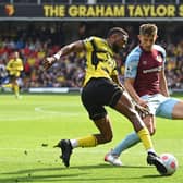 Watford's Nigerian striker Emmanuel Dennis (L) vies with Burnley's English defender James Tarkowski during the English Premier League football match between Watford and Burnley at Vicarage Road Stadium in Watford, north-west of London, on April 30, 2022.