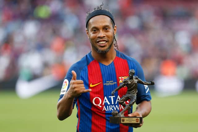 Former Barcelona's Brazilian forward Ronaldinho poses with the trophy for the best player after a charity football match between Barcelona Legends vs Manchester United Legends at the Camp Nou stadium in Barcelona on June 30, 2017. / AFP PHOTO / Pau Barrena        (Photo credit should read PAU BARRENA/AFP via Getty Images)