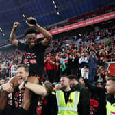 LEVERKUSEN, GERMANY - APRIL 14: Nathan Tella of Bayer Leverkusen celebrates winning the Bundesliga title for the first time in their history after the Bundesliga match between Bayer 04 Leverkusen and SV Werder Bremen at BayArena on April 14, 2024 in Leverkusen, Germany. (Photo by Lars Baron/Getty Images)