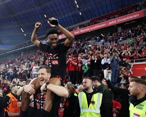 LEVERKUSEN, GERMANY - APRIL 14: Nathan Tella of Bayer Leverkusen celebrates winning the Bundesliga title for the first time in their history after the Bundesliga match between Bayer 04 Leverkusen and SV Werder Bremen at BayArena on April 14, 2024 in Leverkusen, Germany. (Photo by Lars Baron/Getty Images)