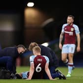 BURNLEY, ENGLAND - MARCH 01: Ben Mee of Burnley receives medical treatment before being substituted during the Premier League match between Burnley and Leicester City at Turf Moor on March 01, 2022 in Burnley, England. (Photo by Lewis Storey/Getty Images)