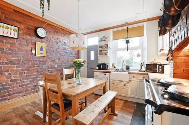 The dining kitchen has two exposed brick feature walls, an Aga oven, cream wooden base and wall units and pine built in units with solid wooden work surfaces.
