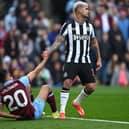 BURNLEY, ENGLAND - MAY 04:  Bruno Guimaraes of Newcastle United sportingly helps up Burnley player Lorenz  Assignon during the Premier League match between Burnley FC and Newcastle United at Turf Moor on May 04, 2024 in Burnley, England. (Photo by Stu Forster/Getty Images)
