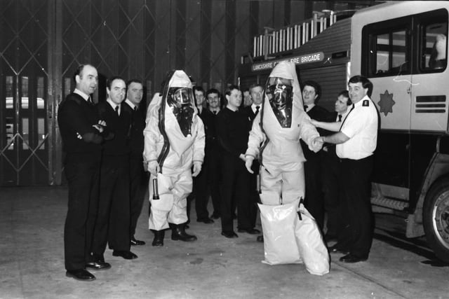 Assistant Divisional Officer Tony Cornwell right, instructing his men on the use of new protective suits