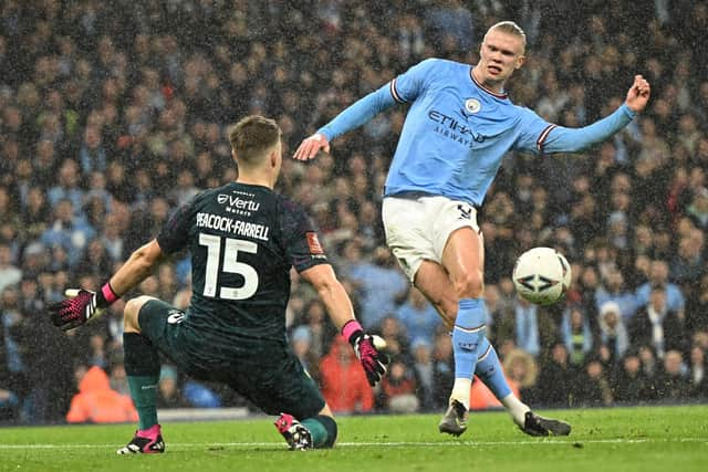 TOPSHOT - Manchester City's Norwegian striker Erling Haaland (R) scores their second goal past Burnley's Northern Irish goalkeeper Bailey Peacock-Farrell (L) during the English FA Cup quarter-final football match between Manchester City and Burnley at the Etihad Stadium in Manchester, north-west England, on March 18, 2023. (Photo by Oli SCARFF / AFP)