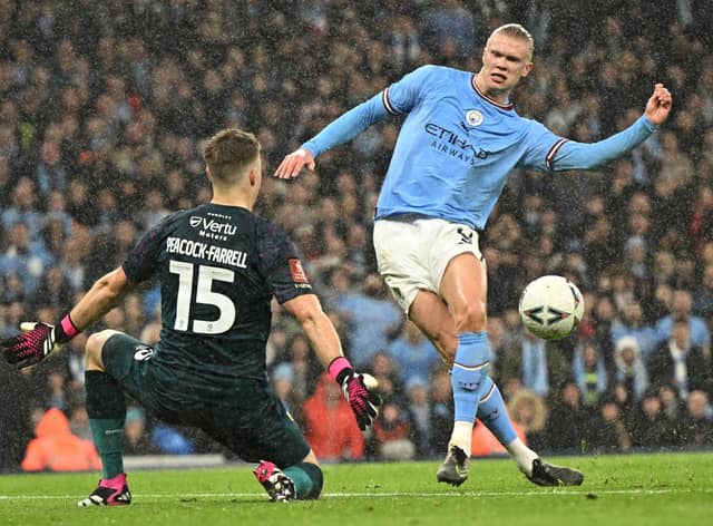 TOPSHOT - Manchester City's Norwegian striker Erling Haaland (R) scores their second goal past Burnley's Northern Irish goalkeeper Bailey Peacock-Farrell (L) during the English FA Cup quarter-final football match between Manchester City and Burnley at the Etihad Stadium in Manchester, north-west England, on March 18, 2023. (Photo by Oli SCARFF / AFP)