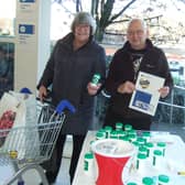 Burnley Lion Brian Hartley presents a 'message in a bottle' pack  to Tesco customer Maureen Bishop.
