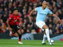 MANCHESTER, ENGLAND - APRIL 24:  Vincent Kompany of Manchester City runs with the ball under pressure from Jesse Lingard of Manchester United during the Premier League match between Manchester United and Manchester City at Old Trafford on April 24, 2019 in Manchester, United Kingdom. (Photo by Catherine Ivill/Getty Images)