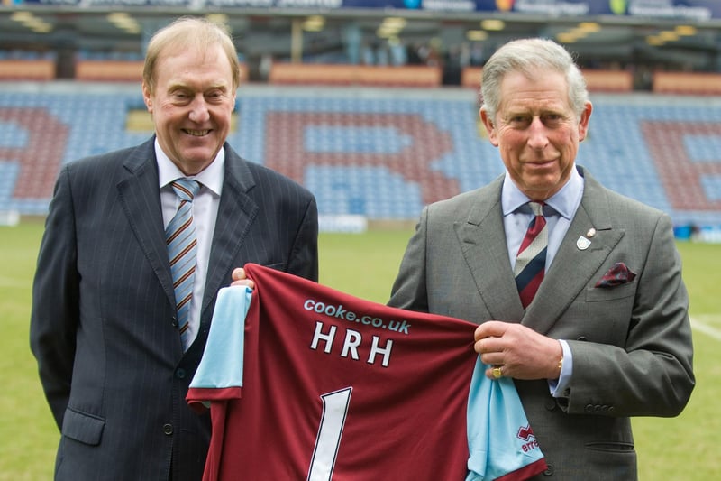 BURNLEY, ENGLAND - FEBRUARY 5:  Prince Charles, Prince of Wales poses with Burnley Chairman Barry Kilby (L) while holding a Burnley football shirt as meets representatives of Burnley Football Club at Turf Moor, the Burnley football club ground on February 5, 2010 in Burnley, England.The Prince was also in Burnley to meet young people who have participated in programmes run by the Prince's Charities.  (Photo by Arthur Edwards/WPA Pool/Getty Images)