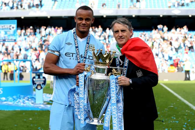 MANCHESTER, ENGLAND - MAY 13:  Vincent Kompany the captain of Manchester City and Roberto Mancini the manager of Manchester City pose with the trophy following the Barclays Premier League match between Manchester City and Queens Park Rangers at the Etihad Stadium on May 13, 2012 in Manchester, England.  (Photo by Alex Livesey/Getty Images)