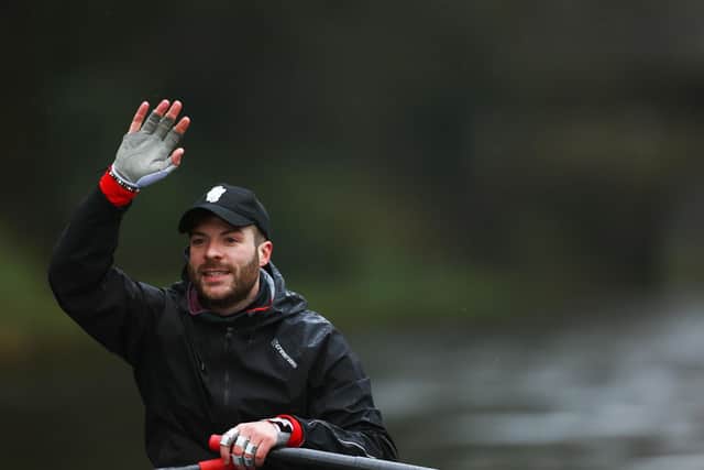 Jordan North manages to raise a a smile as he waves to cheering supporters on his epic 100 mile rowing challenge