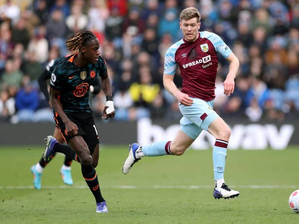BURNLEY, ENGLAND - MARCH 05: Nathan Collins of Burnley runs with the ball from Trevoh Chalobah of Chelsea during the Premier League match between Burnley and Chelsea at Turf Moor on March 05, 2022 in Burnley, England.
