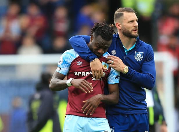 Burnley's Ivorian defender Maxwel Cornet (L) is consoled by Burnley's Dutch defender Erik Pieters on the pitch after the English Premier League football match between Burnley and Newcastle United at Turf Moor in Burnley, north west England on May 22, 2022. - Burnley were relegated from the Premier League on Sunday's final day of the 2021/22 season. The Clarets had to better the result of relegation rivals Leeds to extend their five-season stay in English football's top flight but lost as Leeds won away at Brentford.
 - RESTRICTED TO EDITORIAL USE. No use with unauthorized audio, video, data, fixture lists, club/league logos or 'live' services. Online in-match use limited to 120 images. An additional 40 images may be used in extra time. No video emulation. Social media in-match use limited to 120 images. An additional 40 images may be used in extra time. No use in betting publications, games or single club/league/player publications. (Photo by Lindsey Parnaby / AFP) / RESTRICTED TO EDITORIAL USE. No use with unauthorized audio, video, data, fixture lists, club/league logos or 'live' services. Online in-match use limited to 120 images. An additional 40 images may be used in extra time. No video emulation. Social media in-match use limited to 120 images. An additional 40 images may be used in extra time. No use in betting publications, games or single club/league/player publications. / RESTRICTED TO EDITORIAL USE. No use with unauthorized audio, video, data, fixture lists, club/league logos or 'live' services. Online in-match use limited to 120 images. An additional 40 images may be used in extra time. No video emulation. Social media in-match use limited to 120 images. An additional 40 images may be used in extra time. No use in betting publications, games or single club/league/player publications. (Photo by LINDSEY PARNABY/AFP via Getty Images)