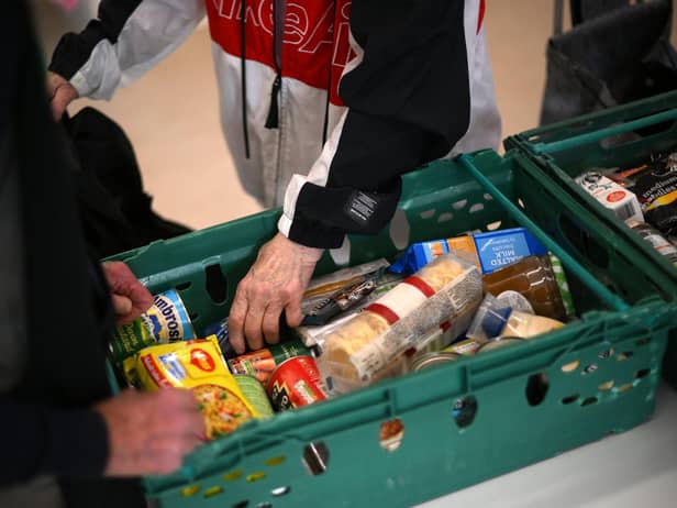 A member the public looks through food items inside a foodbank. (Photo by DANIEL LEAL/AFP via Getty Images)