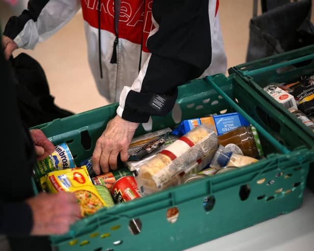 A member the public looks through food items inside a foodbank. (Photo by DANIEL LEAL/AFP via Getty Images)