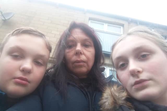 Sarah and two of her children outside their home in Coal Clough Lane which is infested with rats