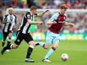 BURNLEY, ENGLAND - MAY 22: Nathan Collins of Burnley runs with the ball whilst under pressure from Matt Targett of Newcastle United during the Premier League match between Burnley and Newcastle United at Turf Moor on May 22, 2022 in Burnley, England. (Photo by Jan Kruger/Getty Images)