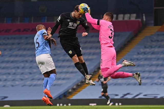 Manchester City's Brazilian goalkeeper Ederson (R) grabs the ball off the head of Burnley's New Zealand striker Chris Wood (C) during the English Premier League football match between Manchester City and Burnley at the Etihad Stadium in Manchester, north west England, on November 28, 2020. (Photo by Laurence Griffiths / POOL / AFP) / RESTRICTED TO EDITORIAL USE. No use with unauthorized audio, video, data, fixture lists, club/league logos or 'live' services. Online in-match use limited to 120 images. An additional 40 images may be used in extra time. No video emulation. Social media in-match use limited to 120 images. An additional 40 images may be used in extra time. No use in betting publications, games or single club/league/player publications. /  (Photo by LAURENCE GRIFFITHS/POOL/AFP via Getty Images)