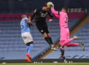 Manchester City's Brazilian goalkeeper Ederson (R) grabs the ball off the head of Burnley's New Zealand striker Chris Wood (C) during the English Premier League football match between Manchester City and Burnley at the Etihad Stadium in Manchester, north west England, on November 28, 2020. (Photo by Laurence Griffiths / POOL / AFP) / RESTRICTED TO EDITORIAL USE. No use with unauthorized audio, video, data, fixture lists, club/league logos or 'live' services. Online in-match use limited to 120 images. An additional 40 images may be used in extra time. No video emulation. Social media in-match use limited to 120 images. An additional 40 images may be used in extra time. No use in betting publications, games or single club/league/player publications. /  (Photo by LAURENCE GRIFFITHS/POOL/AFP via Getty Images)