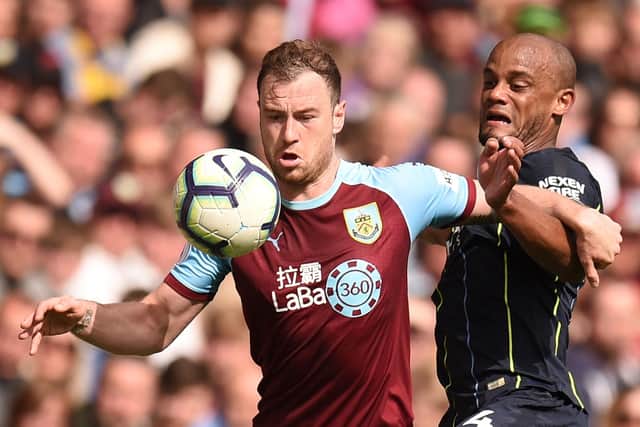 Burnley's English striker Ashley Barnes (L) holds off the attentions of Manchester City's Belgian defender Vincent Kompany (R) during the English Premier League football match between Burnley and Manchester City at Turf Moor in Burnley, north west England on April 28, 2019. (Photo by Oli SCARFF / AFP)