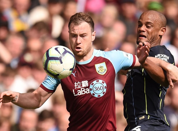 Burnley's English striker Ashley Barnes (L) holds off the attentions of Manchester City's Belgian defender Vincent Kompany (R) during the English Premier League football match between Burnley and Manchester City at Turf Moor in Burnley, north west England on April 28, 2019. (Photo by Oli SCARFF / AFP)