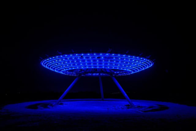 The Haslingdon Halo - an 18m-diameter steel artwork - is illuminated in blue after dark.