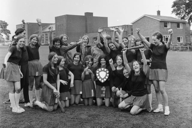 A victory wave from the successful St Hilda's Teams. Junior captain Janice Bannister holds the junior section trophy and next to her senior captain Bella Rowan shows off the senior section shield.