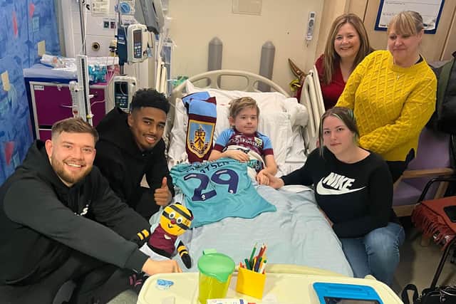 Charlie Paine receives a visit from Burnley player Ian Maatsen at the Royal Manchester Children's Hospital, surrounded by his dad Kieran, mum Megan and his grandma Elizabeth McCabe and nan Jane Foster